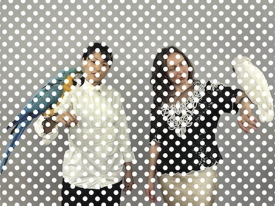 Two women with birds perched on outstretched arms