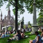 image of people sitting in green-wood cemetery